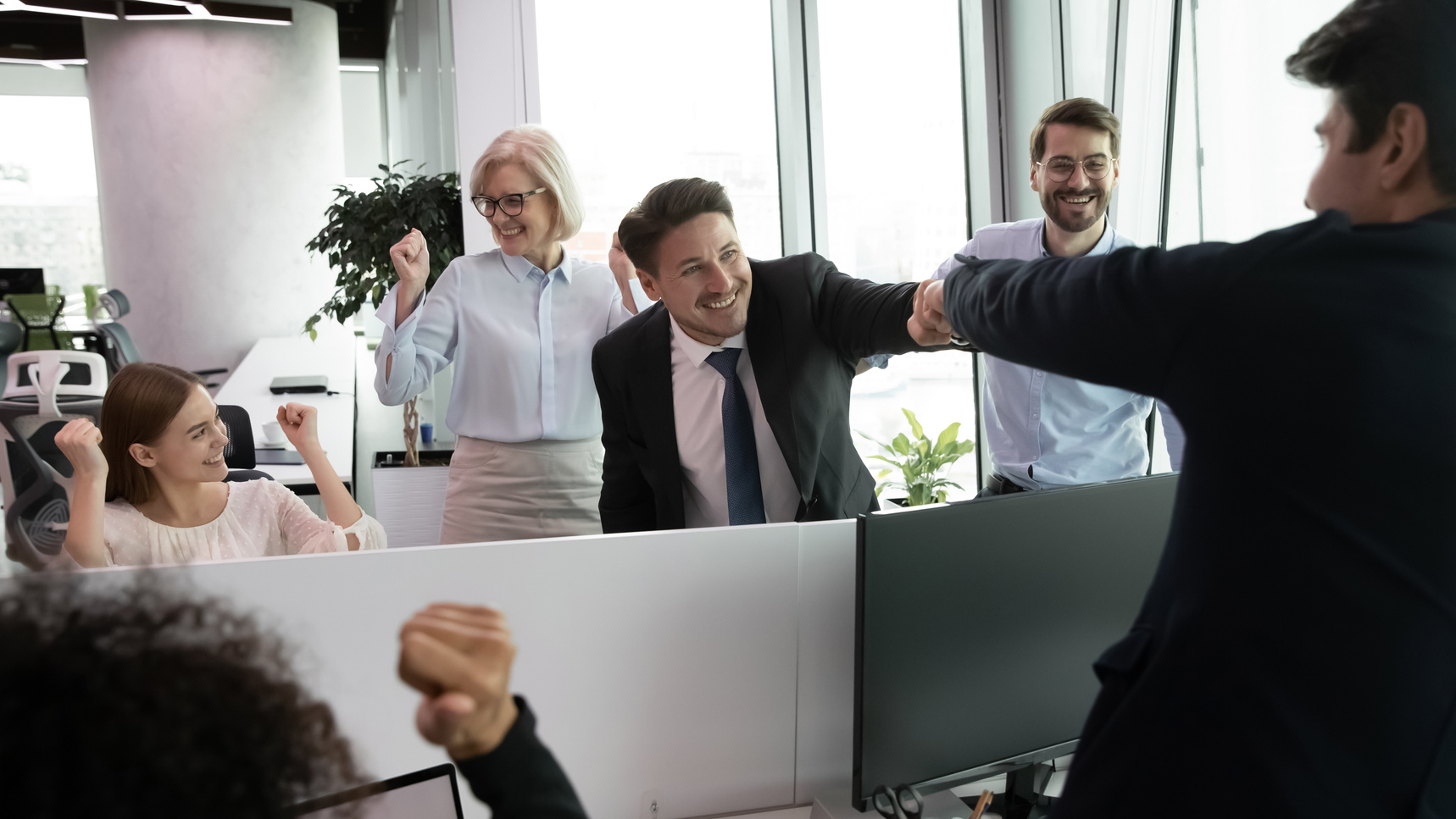 Happy businessman bumping collegues fist greeting with professional growth, success